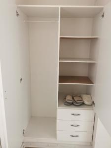 a white closet with white shelves and shoes at Håstrups Natur Perle in Faaborg