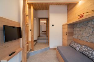 a living room with a tv and a couch at Casera Pian Grand Wellness Lodge in Chies dʼAlpago