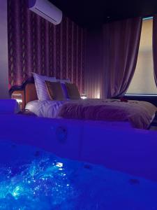 a bedroom with two beds and a window with a blue light at Hôtel Mademoiselle in Liège