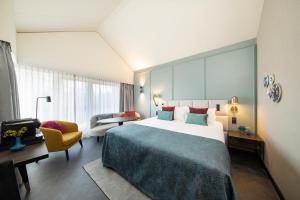 een hotelkamer met een groot bed en een stoel bij Bilderberg Hotel De Keizerskroon in Apeldoorn