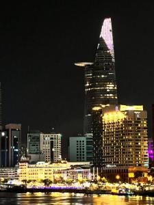 een skyline van de stad 's nachts met een hoog gebouw bij Nhaanhouse Sunrise City in Ho Chi Minh-stad