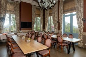 une salle à manger avec des tables et des chaises ainsi qu'un lustre dans l'établissement Boeckhaege vakantiewoning, à Ronse