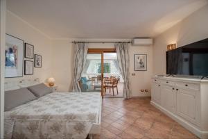 a bedroom with a bed and a flat screen tv at Sweet Mavy Incantevole Dimora by Wonderful Italy in Porto Rotondo