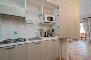 a kitchen with a sink and a microwave at Sweet Mavy Incantevole Dimora by Wonderful Italy in Porto Rotondo