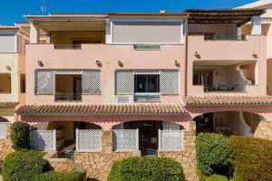 a pink building with bushes in front of it at Sweet Mavy Incantevole Dimora by Wonderful Italy in Porto Rotondo