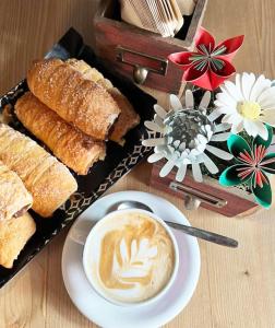 un tavolo con una tazza di caffè e un piatto di pane di La Casa in Paese a Peschiera del Garda