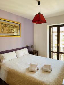 una camera da letto con un grande letto con due cuscini sopra di Apartamentos Zaragoza Coso a Saragozza