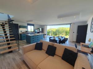a living room with a couch and a dining room at Mont-Vert exotique - Calme - Vue et PARKING in Saint-Pierre