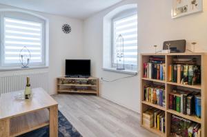 a living room with a tv and book shelves at Mina in Krauchenwies