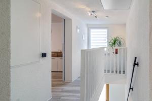 a white hallway with a white staircase in a house at Mina in Krauchenwies