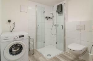 a bathroom with a shower and a washing machine at Mina in Krauchenwies