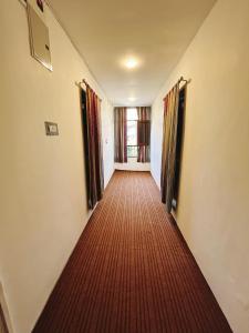a hallway with a red carpeted floor and windows at Sea Green Guest House in Srinagar