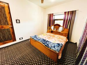 a small bedroom with a bed and a window at Sea Green Guest House in Srinagar +23 photos