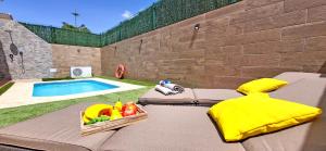un patio amueblado con un bol de fruta junto a la piscina en Ferienhaus CASA ELA, en Tarajalejo