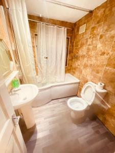 Charming 3-Bed holiday House in Birmingham في برمنغهام: حمام مع مرحاض وحوض استحمام ومغسلة