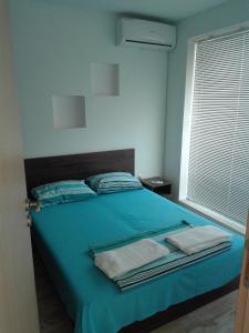 ヴァルナ・シティにあるMaisonette Sevastopolのベッドルーム1室(ブルーベッド1台、タオル付)