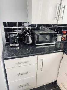 a kitchen with a counter top with a microwave at Charming 3-Bed holiday House in Birmingham in Birmingham
