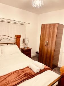a bedroom with two beds and a wooden cabinet at Charming 3-Bed holiday House in Birmingham in Birmingham