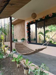 a hammock in a room with plants at Onur Inn in El Nido