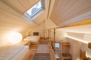 a small bedroom with two beds and a skylight at Casera Moda Luxury Chalet in Chies dʼAlpago
