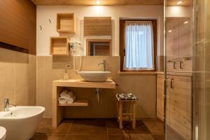 a bathroom with a sink and a mirror at Casera Moda Luxury Chalet in Chies dʼAlpago