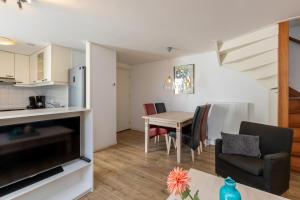 een keuken en eetkamer met een tafel en stoelen bij Welcome in - Knusse vakantiewoning met zonnig terras in het gezellige Domburg in Domburg +23 foto's
