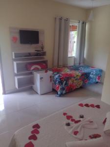 a bedroom with a bed with hearts on the floor at Pousada Sítio da Floresta in Sana
