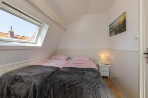 een kleine slaapkamer met een bed en een raam bij Kanonweistraat 11a, Domburg in Domburg