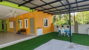Sri MaLati Homestay and Event Space في باليك بولاو: منزل مع فناء مع طاولة وكراسي