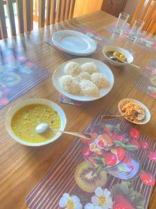 a wooden table with plates of food on it at Happy Feet Diyaluma in Koslanda