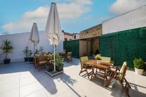 un patio con mesas y sombrillas en la azotea en The Easy Rooms Terrace, en Antalya