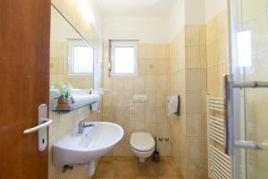 uma casa de banho com um lavatório branco e um WC. em Guesthouse Villa Irena em Zadar