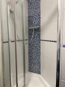 a shower with a glass door in a bathroom at Rose Cottage Trecynon Traditional 2 bed cottage Zip World Beacons Bike in Aberdare