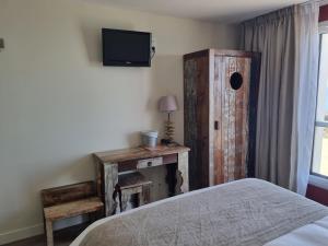 a bedroom with a bed and a tv on the wall at Hôtel Vauban in Le Palais