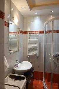 uma casa de banho com um lavatório e um chuveiro em Cozy Apartment Νear Nea Paralia of Thessaloniki em Tessalônica