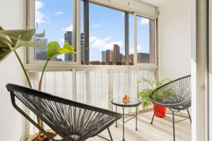 Zimmer mit 2 Stühlen und einem großen Fenster in der Unterkunft Apartamento cerca de la playa in Barcelona