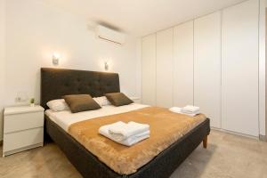 a bedroom with a large bed with two towels on it at Apartamento cerca de la playa in Barcelona