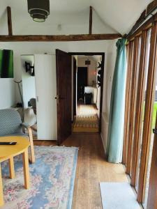 a living room with a hallway with a table and a room at The Retreat in Tibenham