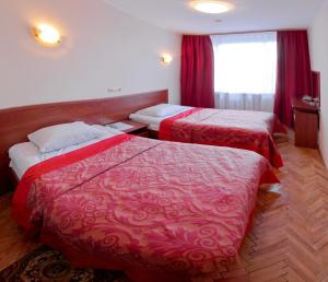 een hotelkamer met twee bedden en een raam bij Hetman Hotel in Lviv