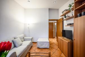 - un salon avec un canapé et une télévision dans l'établissement Intimo appartamento sui tetti di Verona, à Vérone