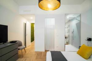 een slaapkamer met een bed en een televisie en een spiegel bij Atmosfere luxury apartment in Bergamo