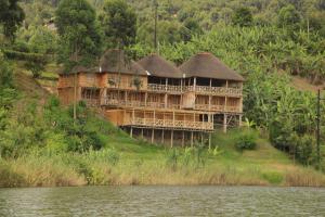 a large house on a hill next to a body of water at Keije Resort Bunyonyi in Kabale