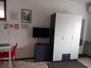 uma sala de estar com um armário branco e uma televisão em Rooms Sobe ZG em Zagreb