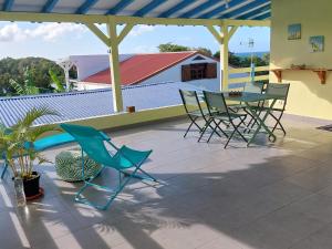 patio z krzesłami i stołem na dachu w obiekcie Calme Villa w mieście Sainte-Rose