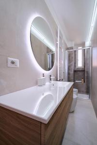 ein Bad mit einem Waschbecken und einem Spiegel in der Unterkunft suity I cozy leila apartment in Mailand