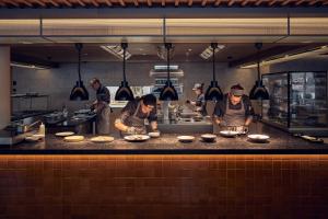 grupa kucharzy przygotowujących jedzenie w kuchni w obiekcie Falkensteiner Hotel Kronplatz - The Leading Hotels of the World w mieście Brunico