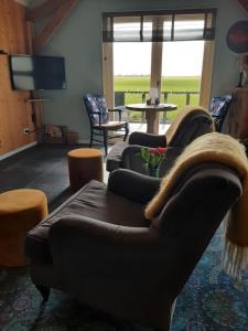a living room with two couches and a tv at B&B De Verre Kijker in Barsingerhorn