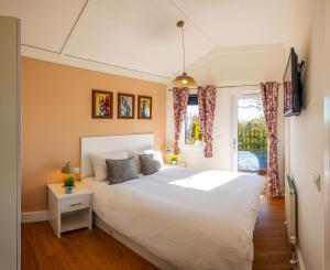 a bedroom with a large white bed and a window at Montana Log Cabin - Ockeridge Rural Retreats in Wichenford