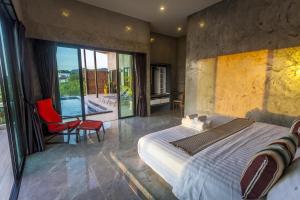 a bedroom with a bed and a view of a pool at Stylish Pool Villa - 10 Mins Walk To The Beach in Ko Lanta