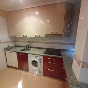 Il comprend une cuisine équipée d'un lave-linge et d'un évier. dans l'établissement Apartamento en Gijon, à Gijón